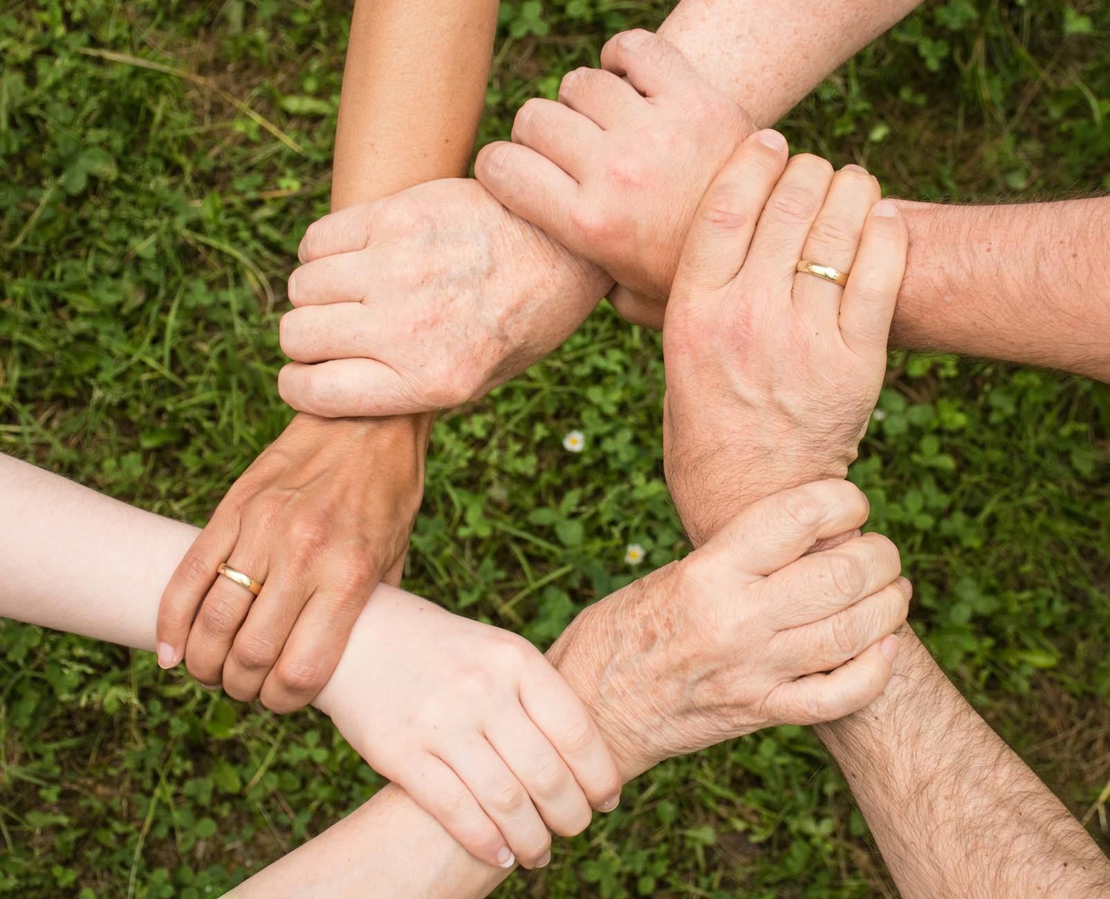 group of people holding arms